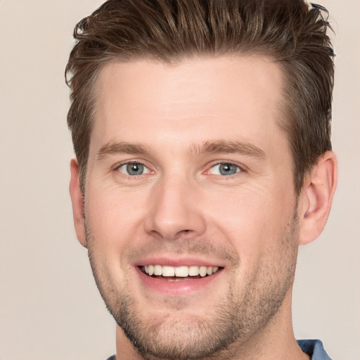 Joyful white young-adult male with short  brown hair and grey eyes