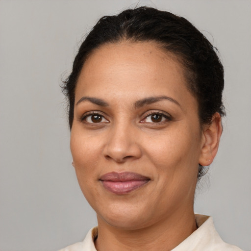 Joyful latino adult female with short  brown hair and brown eyes