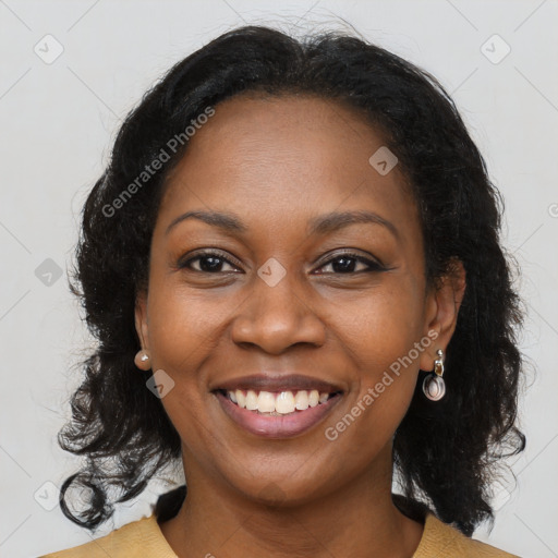 Joyful black young-adult female with long  brown hair and brown eyes