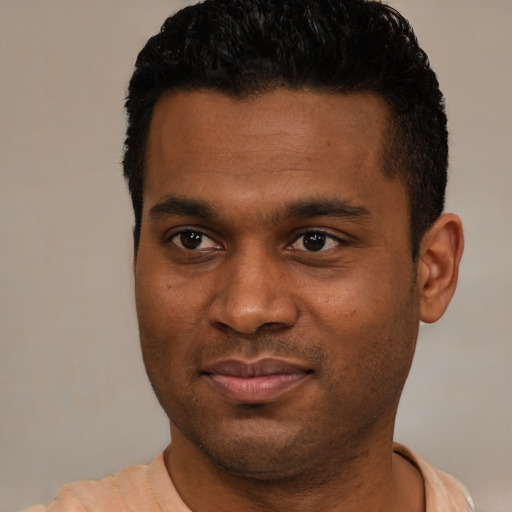 Joyful black young-adult male with short  black hair and brown eyes