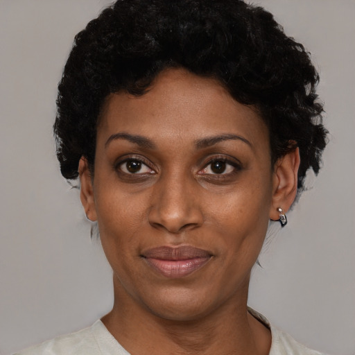 Joyful black adult female with short  black hair and brown eyes