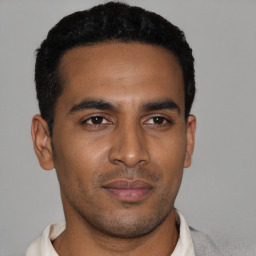 Joyful black young-adult male with short  black hair and brown eyes