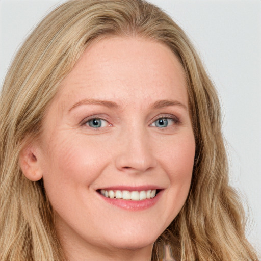 Joyful white young-adult female with long  brown hair and blue eyes