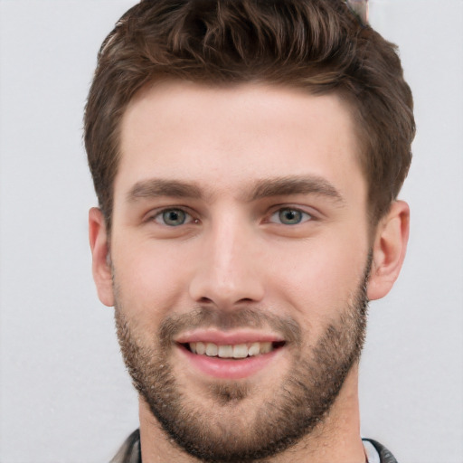 Joyful white young-adult male with short  brown hair and grey eyes