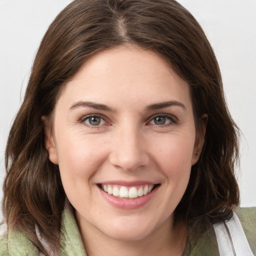 Joyful white young-adult female with medium  brown hair and grey eyes