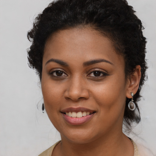 Joyful black young-adult female with long  brown hair and brown eyes