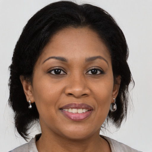 Joyful black adult female with medium  brown hair and brown eyes