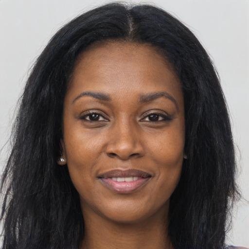Joyful black young-adult female with long  black hair and brown eyes