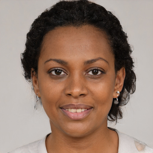 Joyful black young-adult female with medium  black hair and brown eyes