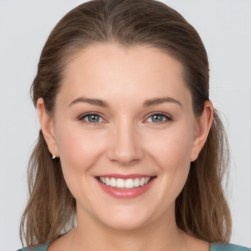 Joyful white young-adult female with medium  brown hair and grey eyes