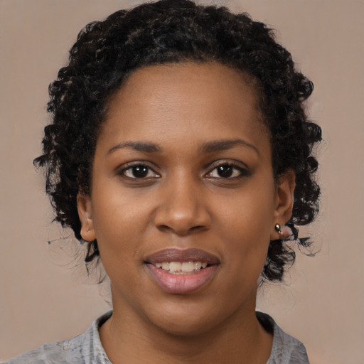 Joyful black young-adult female with short  brown hair and brown eyes