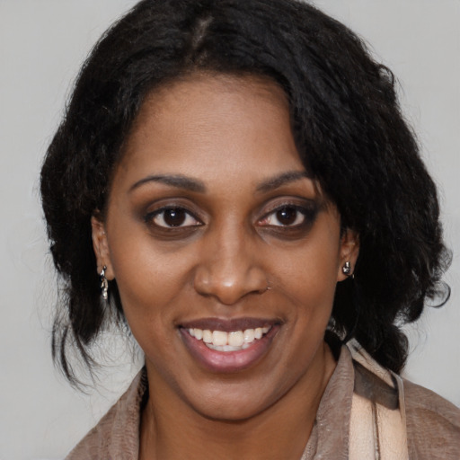 Joyful black young-adult female with medium  brown hair and brown eyes