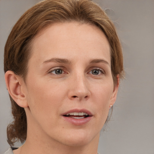 Joyful white adult female with medium  brown hair and grey eyes