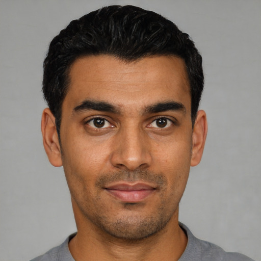 Joyful latino young-adult male with short  black hair and brown eyes