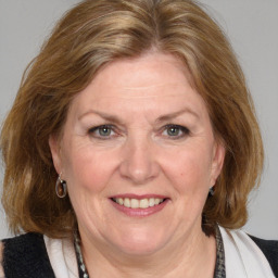 Joyful white adult female with medium  brown hair and blue eyes