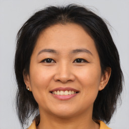 Joyful asian young-adult female with medium  brown hair and brown eyes