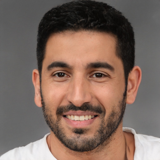 Joyful latino young-adult male with short  black hair and brown eyes