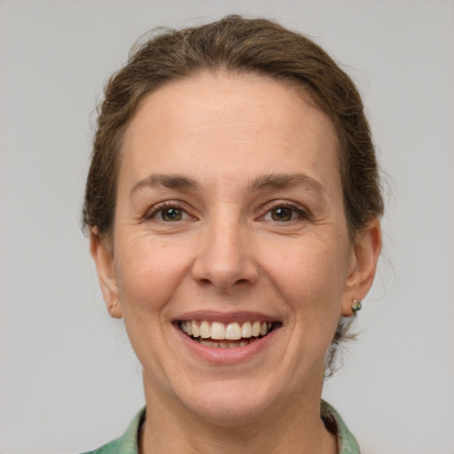 Joyful white adult female with short  brown hair and green eyes