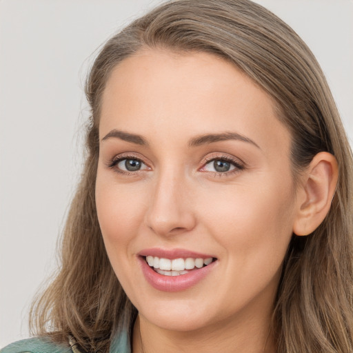 Joyful white young-adult female with long  brown hair and blue eyes