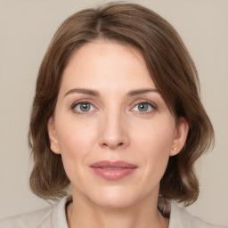 Joyful white young-adult female with medium  brown hair and green eyes