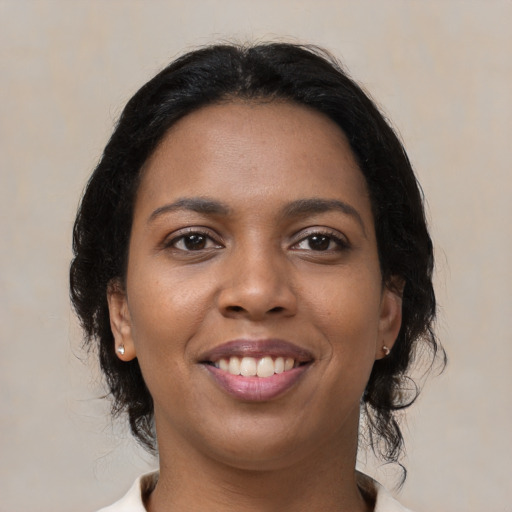 Joyful black young-adult female with medium  black hair and brown eyes