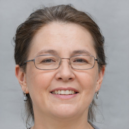 Joyful white adult female with medium  brown hair and grey eyes