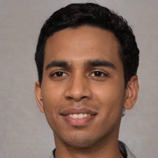 Joyful latino young-adult male with short  black hair and brown eyes