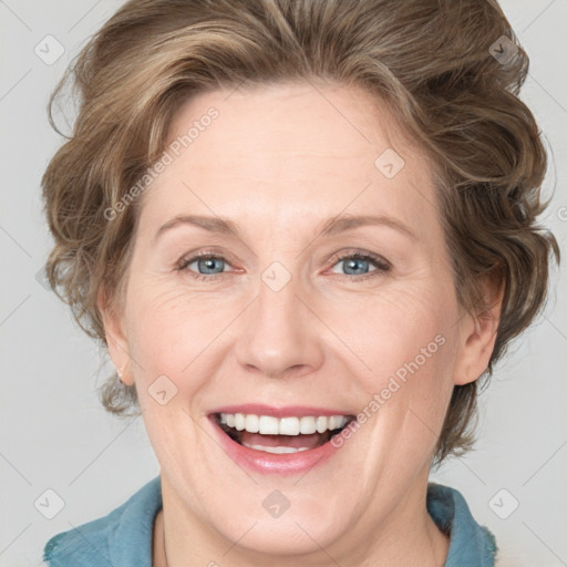 Joyful white adult female with medium  brown hair and blue eyes