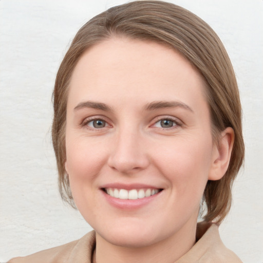 Joyful white young-adult female with medium  brown hair and blue eyes