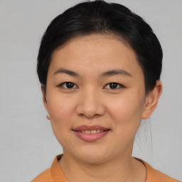 Joyful asian young-adult female with short  black hair and brown eyes