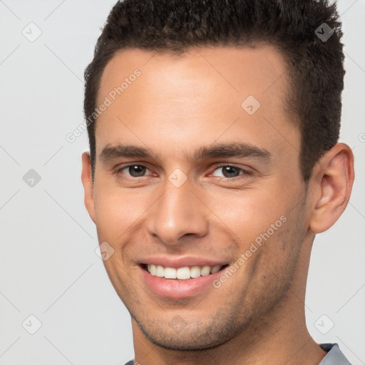 Joyful white young-adult male with short  brown hair and brown eyes