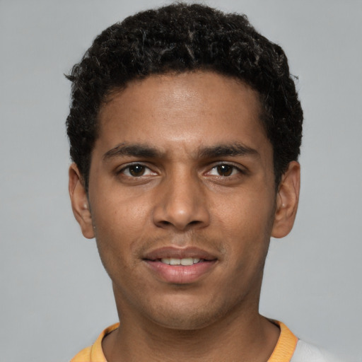 Joyful black young-adult male with short  black hair and brown eyes