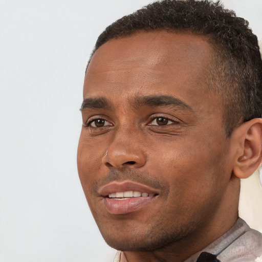 Joyful black young-adult male with short  brown hair and brown eyes