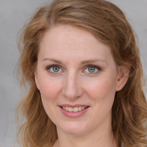 Joyful white adult female with long  brown hair and blue eyes