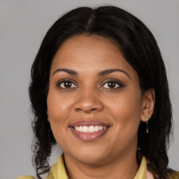 Joyful black young-adult female with medium  brown hair and brown eyes