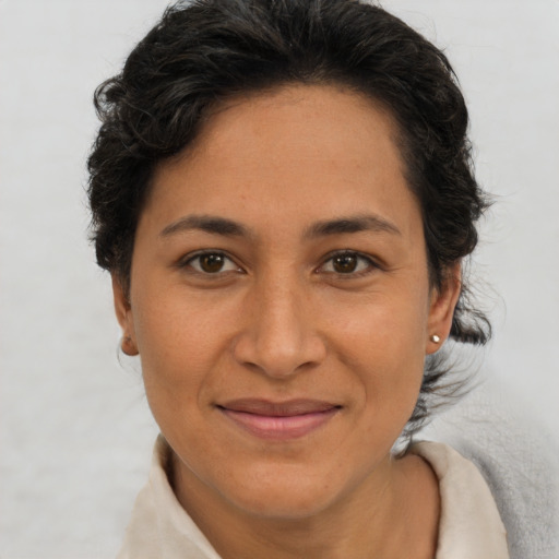 Joyful latino adult female with short  brown hair and brown eyes
