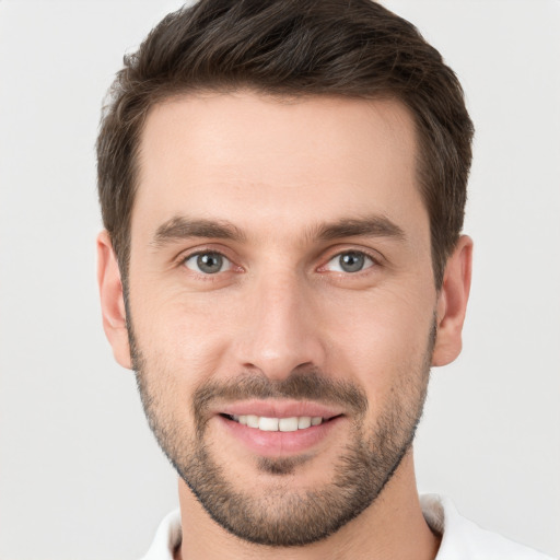 Joyful white young-adult male with short  brown hair and grey eyes