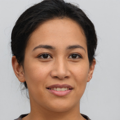 Joyful latino young-adult female with medium  brown hair and brown eyes