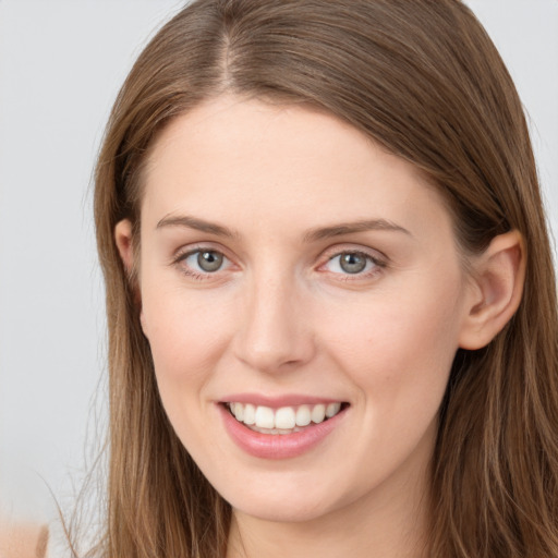 Joyful white young-adult female with long  brown hair and grey eyes