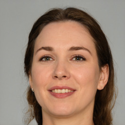 Joyful white adult female with medium  brown hair and green eyes