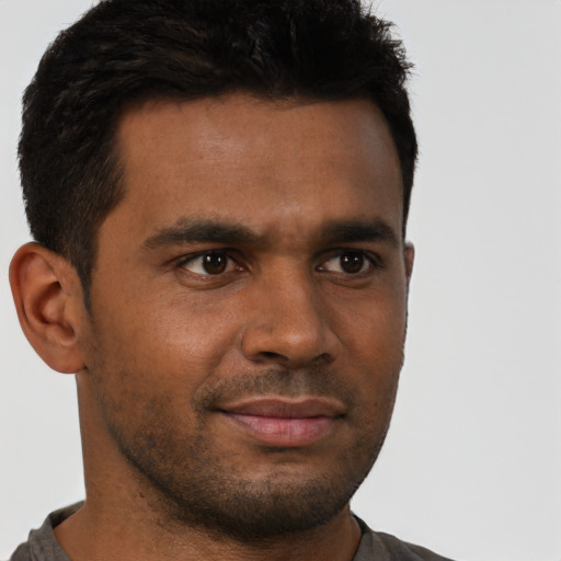 Joyful black young-adult male with short  brown hair and brown eyes