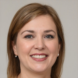 Joyful white young-adult female with long  brown hair and grey eyes