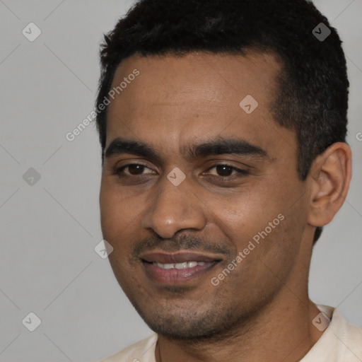 Joyful black young-adult male with short  black hair and brown eyes