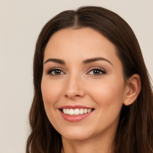 Joyful white young-adult female with long  brown hair and brown eyes