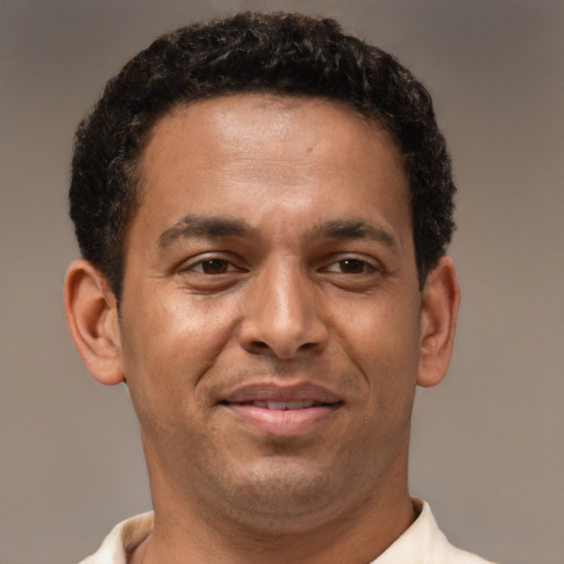 Joyful latino adult male with short  brown hair and brown eyes