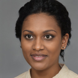Joyful black young-adult female with short  black hair and brown eyes