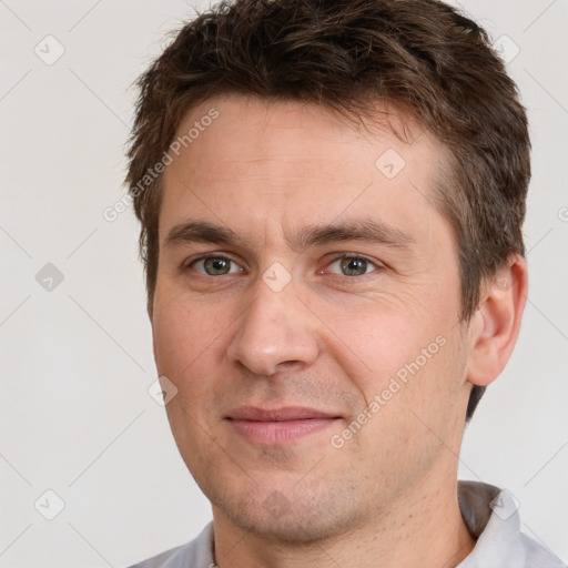 Joyful white adult male with short  brown hair and brown eyes