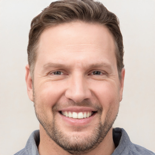 Joyful white adult male with short  brown hair and grey eyes