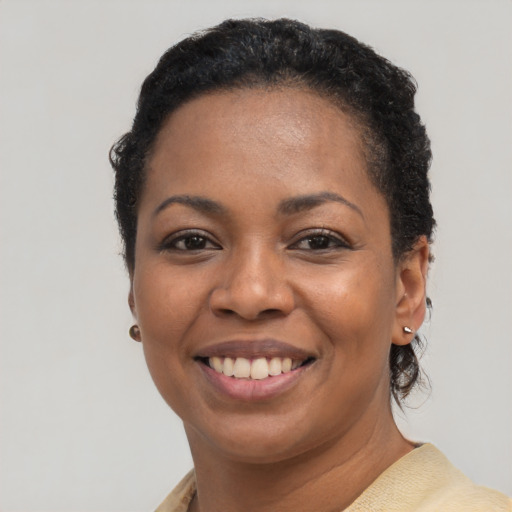 Joyful black young-adult female with short  black hair and brown eyes