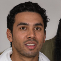 Joyful latino young-adult male with short  brown hair and brown eyes